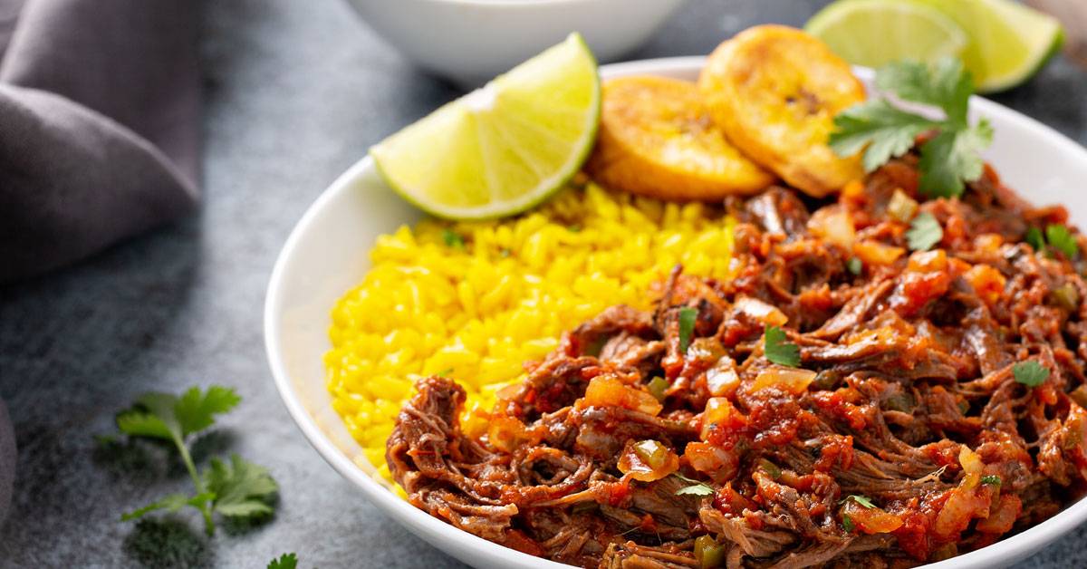 Ropa vieja with yellow rice and fried plantains